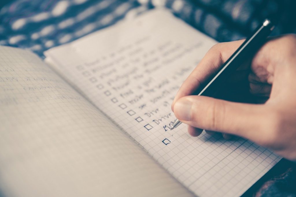writing down a checklist in a notebook