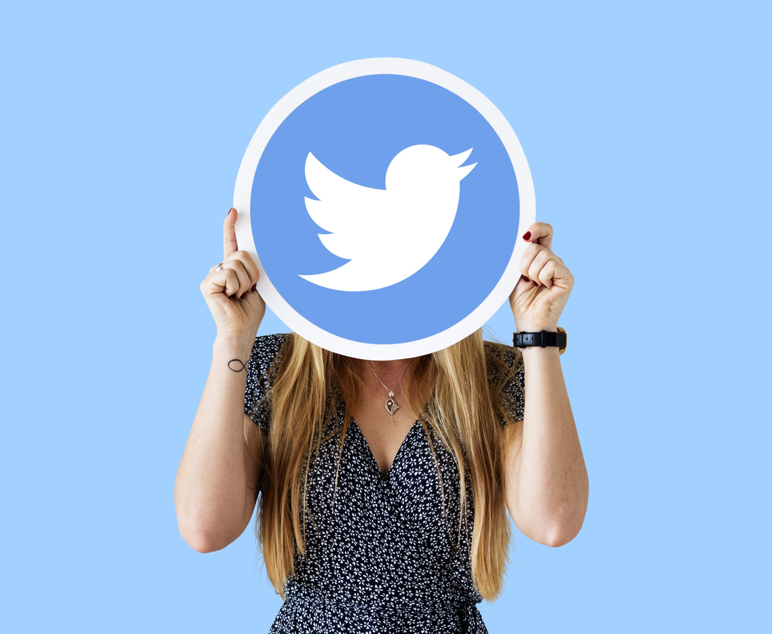 Woman covering her face with a large rounded Twitter logo